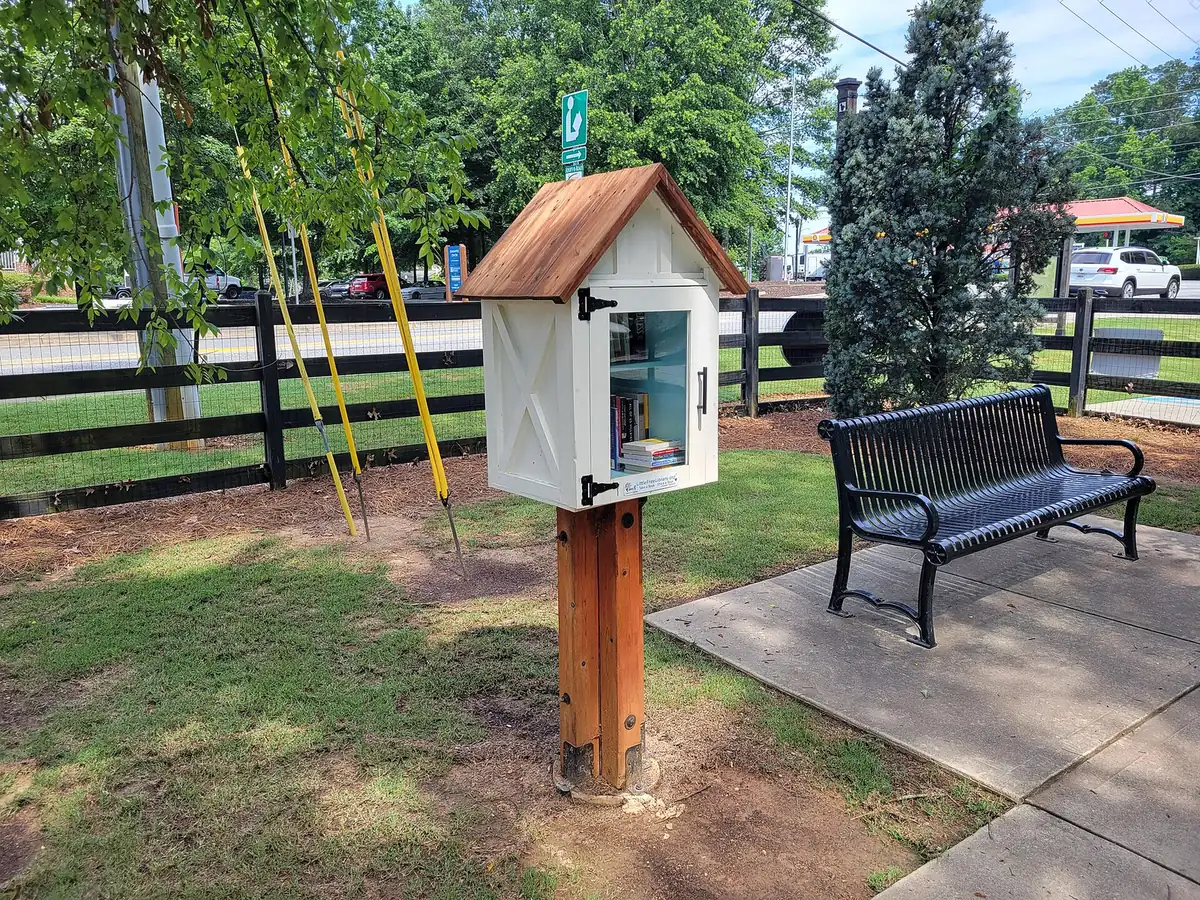 A Little Free Library and bench beside Crabapple Road in downtown Crabapple, Milton's main shopping district