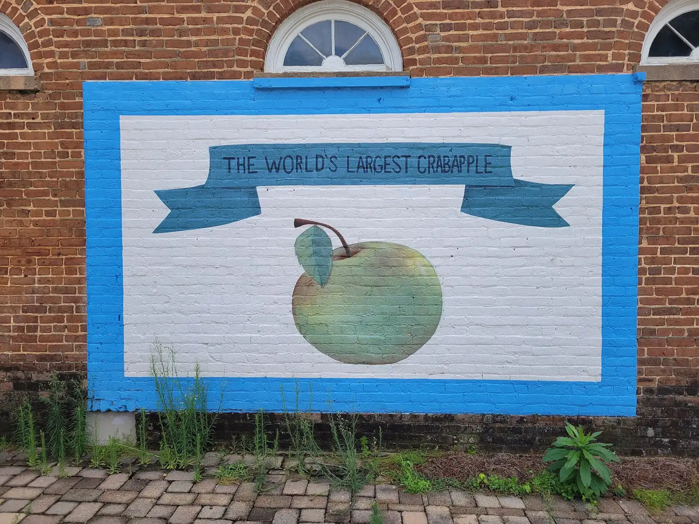 The World's Largest Crabapple mural on a brick wall in downtown Crabapple, a short walk from Broadwell Pavilion