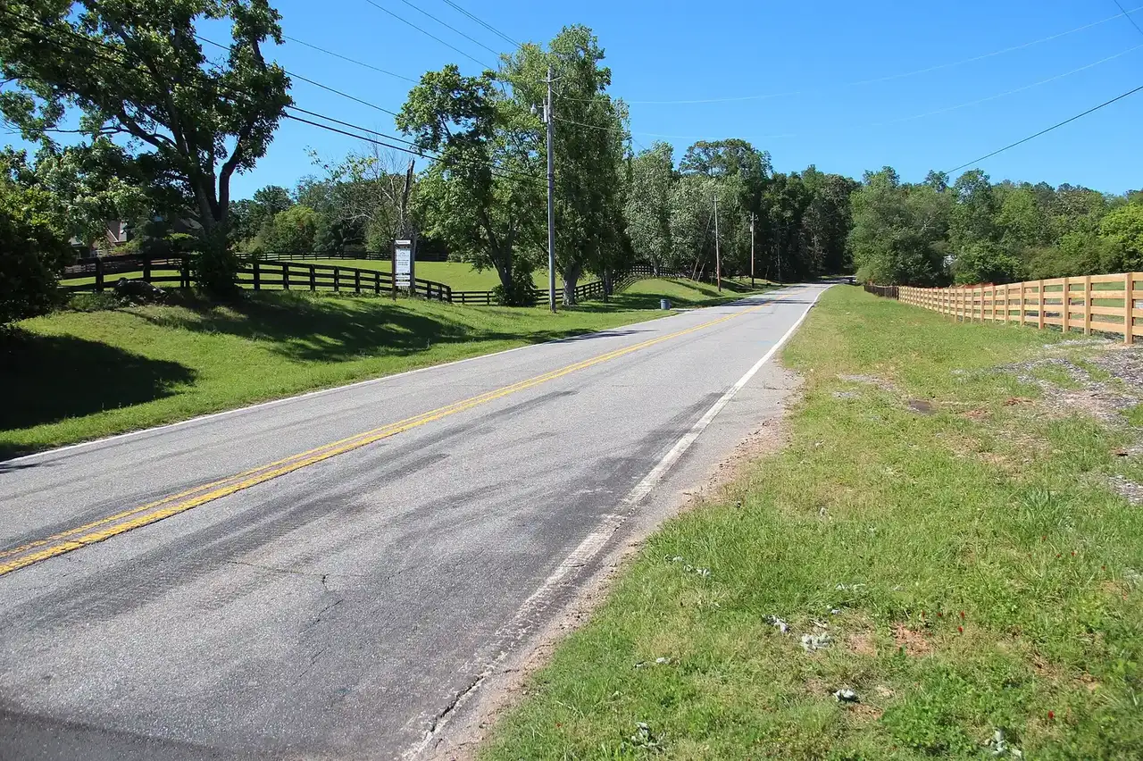 Freemanville Road, a two-lane road past pasture and fencing in Milton