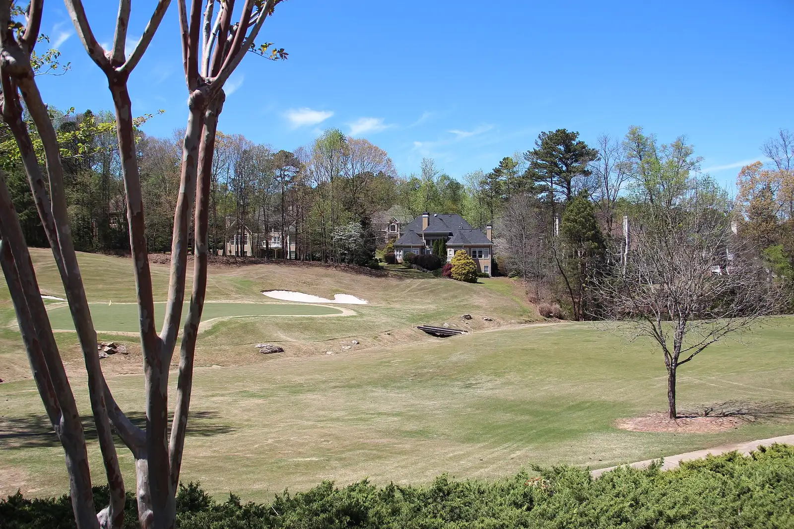 A green on the Crooked Creek golf course, with homes beyond, in the Bethany area of Milton